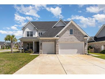 Stunning two-story home featuring a brick facade, attached two-car garage, and a well-manicured lawn at 801 Celene Ct., Myrtle Beach, SC 29579