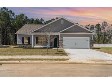 Charming single-story home with gray siding, stone accents, and a spacious two-car garage at 108 Old Chimney Ln, Conway, SC 29526