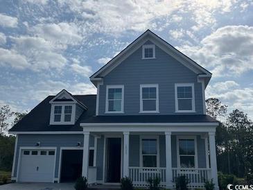 Charming two-story home with light blue siding, white trim, and a welcoming front porch at 1733 Tryon Dr, Myrtle Beach, SC 29588