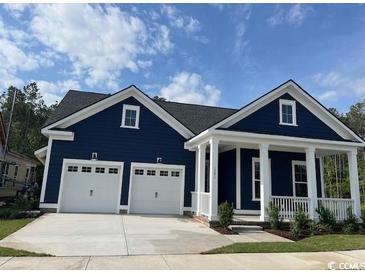 Charming single-Gathering home boasts a striking blue exterior and a two-car garage and inviting front porch at 1781 Tryon Dr, Myrtle Beach, SC 29588