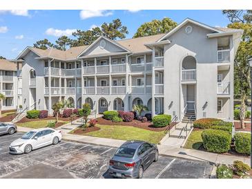 Three-story building with multiple units, white balconies, and landscaped grounds and parking at 4430 Eastport Blvd. # L15, Little River, SC 29566