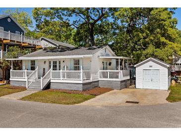 Charming single-story home with a white picket fence, covered porch, and detached garage at 6001-7035 S Kings Hwy., Myrtle Beach, SC 29575