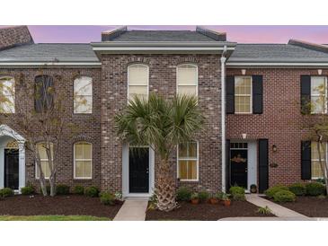 Charming brick townhome featuring a well-manicured lawn and a stylish black front door at 830 Howard Ave. # D, Myrtle Beach, SC 29577