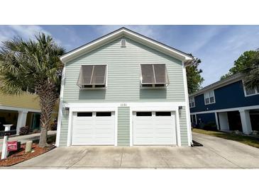 Two-story beach house with a two-car garage and a palm tree in the front yard at 1131 Camellia Dr., Surfside Beach, SC 29575