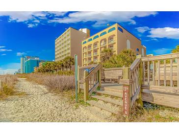 Direct beach access with a wooden walkway and stairs, leading to beautiful condominium buildings and sunny skies at 1207 S Ocean Blvd. S # 50910, Myrtle Beach, SC 29577