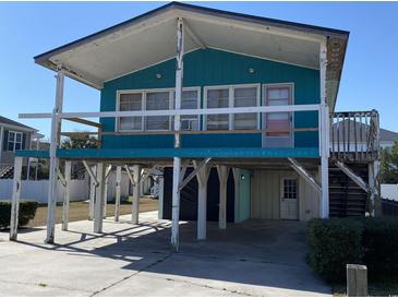 A stilted teal home showcasing the structure and access stairs, needing some love at 317 29Th Ave. N, North Myrtle Beach, SC 29582