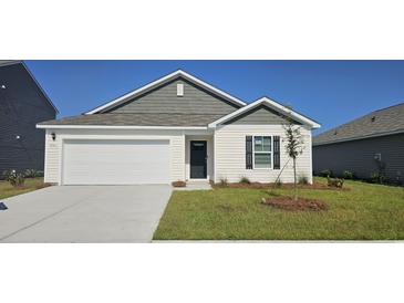 Charming single-Gathering home featuring a well-manicured lawn and an attached garage at 4496 East Coast Ln., Shallotte, NC 28470
