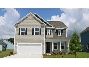 Charming two-story home featuring a two-car garage, neutral siding, and classic black shutters against a bright blue sky at 6027 Forest Dell Ct, Myrtle Beach, SC 29579