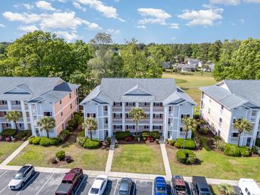 An inviting view of a condo building, with lush landscaping, golf course, parking area and well-maintained lawns at 619 Waterway Village Blvd. # 7C, Myrtle Beach, SC 29579