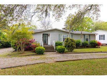 Charming one-story home with a well-maintained lawn, gravel drive, and inviting front entrance at 835 South Marlin Circle, Murrells Inlet, SC 29576