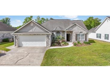 Charming single-story home featuring brick accents, well-maintained landscaping, and an attached two-car garage at 121 Ashworth Dr., Little River, SC 29566