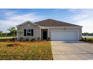 Charming single-story home featuring a two-car garage and manicured front lawn with a view of the lake at 1434 Nokota Dr., Conway, SC 29526