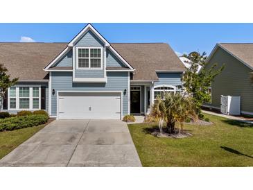 Charming blue home featuring an attached garage and well-maintained front yard at 320 Saint Catherine Bay Ct., Surfside Beach, SC 29575