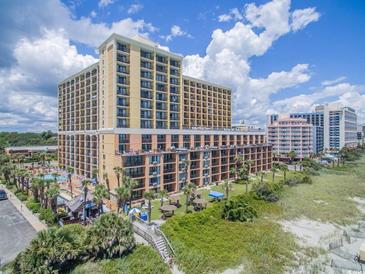 Expansive aerial view of a beachfront high-rise resort with lush landscaping and a pool area at 6900 Ocean Blvd. N # 1114, Myrtle Beach, SC 29572