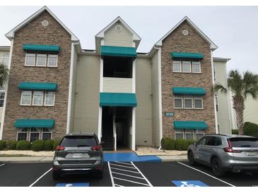 Beautiful exterior view of a condo building featuring stone accents and teal awnings with accessible parking at 9739 Leyland Dr. # 12, Myrtle Beach, SC 29572