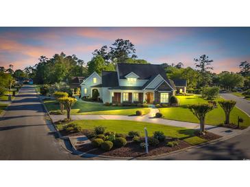 Beautiful traditional home with manicured lawn, lovely landscaping, and circular driveway at 107 Long Bay Golf Pl., Longs, SC 29568