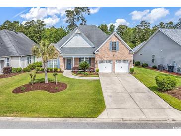 Charming brick home featuring a well-manicured lawn, mature trees, and a spacious driveway at 120 Whitemarsh Ct., Murrells Inlet, SC 29576