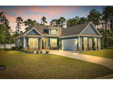 Charming blue two-story home featuring a well-manicured lawn and an attached two-car garage at 1509 Osage Dr., Myrtle Beach, SC 29579