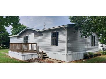 Charming mobile home featuring light gray siding and a small wooden porch with traditional railings at 3802 Stern Dr., Conway, SC 29526