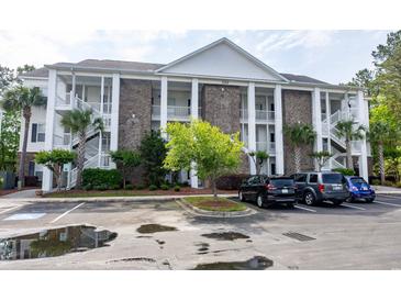 Three-story condo with brick accents, white columns, stairs, and ample parking at 100 Birch N Coppice Dr. # 12, Surfside Beach, SC 29575