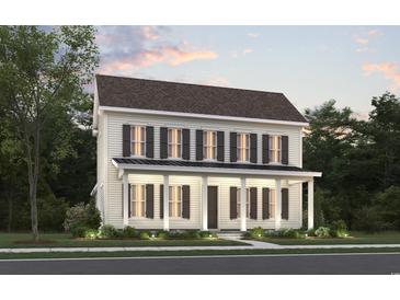 Charming two-story home with a welcoming front porch and classic architectural details surrounded by mature trees at 1804 Tryon Dr, Myrtle Beach, SC 29588