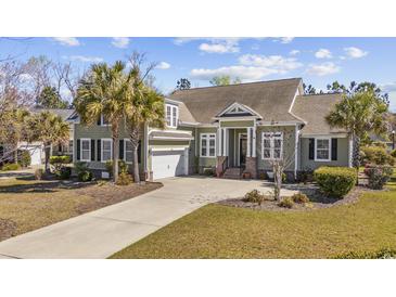 Charming home featuring a well-manicured lawn, palm trees, and a convenient two-car garage at 200 Stonefly Ct., Murrells Inlet, SC 29576