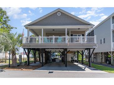 Inviting elevated beach home with covered parking and a charming front porch perfect for enjoying coastal breezes at 6001-1872 S Kings Hwy., Myrtle Beach, SC 29575