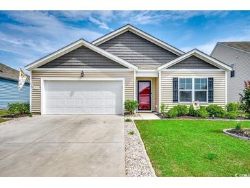 Charming single-story home with a well-maintained lawn, attached garage, and inviting front entrance at 777 Woodland Farms Circle, Aynor, SC 29511