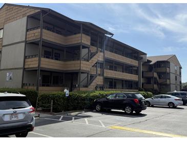 A view of the condo building's exterior with a parking lot and neatly trimmed hedges at 9501 Shore Dr. # D-237, Myrtle Beach, SC 29572