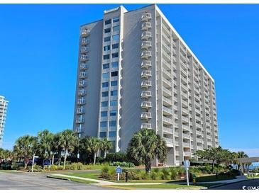 Condo building exterior shot showing meticulous landscaping and beautiful blue skies at 9820 Queensway Blvd. # 704, Myrtle Beach, SC 29572