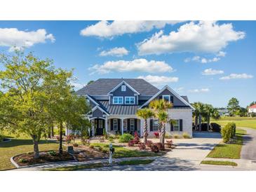Charming two-story home with a manicured lawn, beautiful landscaping, and a welcoming front porch at 1017 Gallinule Dr., Conway, SC 29526