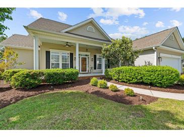 Charming home featuring a well-manicured lawn, inviting front porch, and beautiful landscaping at 246 Laurel Bay Dr., Murrells Inlet, SC 29576