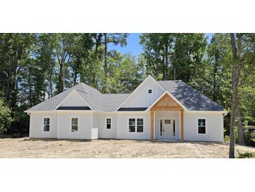 Charming, new construction, single-story home with a gray roof and a welcoming wooden-beam front entrance at 25 Pinewood Dr., Carolina Shores, SC 28467