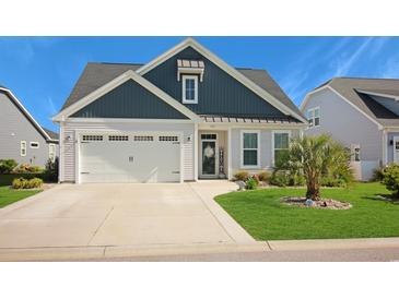 Charming single-story home with a well-manicured lawn, two-car garage, and welcoming front entrance at 3024 Calusa Dr., Little River, SC 29566
