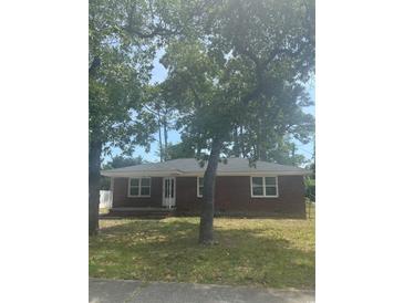 Charming single-story brick home featuring a well-manicured front yard and mature trees at 3816 Pine Lake Dr., Myrtle Beach, SC 29577