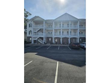 Beautiful three-story condo building with a parking lot and covered balconies at 4449 Turtle Ln. # 3A, Little River, SC 29566