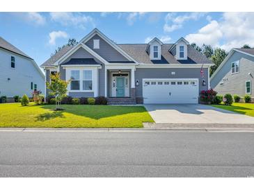 Charming single-story home featuring a well-manicured lawn and a beautiful blue front door at 537 Indigo Bay Circle, Myrtle Beach, SC 29579