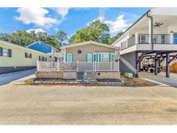 Charming home featuring a cozy front porch with white railing and blue shutters at 6001-1592 South Kings Hwy., Myrtle Beach, SC 29575