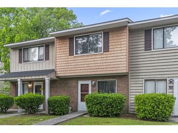 Charming two-story townhome with brick and wood facade, complemented by well-maintained landscaping and a quaint walkway at 86 Beaver Pond Loop # 33, Pawleys Island, SC 29585