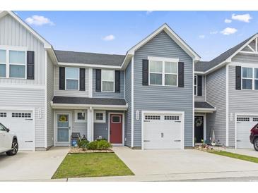 Charming townhome featuring well-maintained landscaping, a red front door, and an attached garage at 136 Villa Grande St. # B, Myrtle Beach, SC 29579