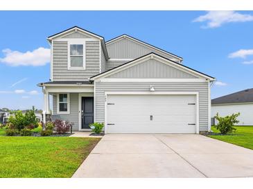 Charming two-story home with a well-manicured lawn and attached two car garage on a sunny day at 189 Timber Oaks Dr., Myrtle Beach, SC 29588