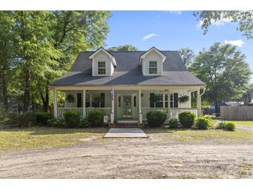 Charming home with a welcoming front porch and well-manicured landscaping at 228 Hopeland St., Pawleys Island, SC 29585