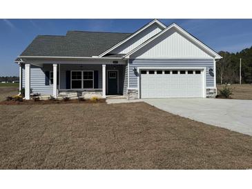 Charming single-story home featuring a two-car garage and a welcoming front porch with decorative stone accents at 4959 Dupont Rd., Aynor, SC 29511