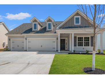 Charming home featuring a three-car garage, well-manicured lawn, and inviting entrance at 609 Carter Reid Ct., Longs, SC 29568
