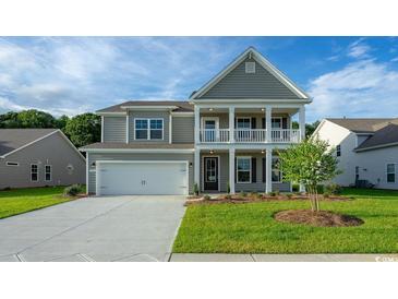 Charming two-story home with a gray exterior, landscaped lawn, and attached two-car garage at 867 Ireland Dr., Longs, SC 29568