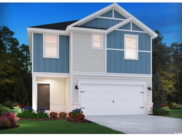 Charming two-story home boasts blue and gray siding, a two-car garage, and a welcoming front door and landscaped yard at 882 Cypress Preserve Circle, Longs, SC 29568