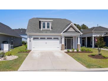 Charming single-Gathering home with a gray exterior, well-manicured lawn, and a two-car garage at 1031 Cascade Loop, Little River, SC 29566