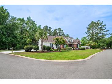 Charming curb appeal with lush lawn, mature trees, and a mix of brick and siding on this two story home at 12 Gloucester Pl., Pawleys Island, SC 29585