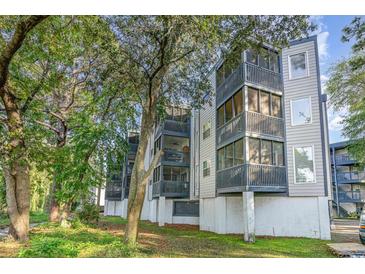 Condominium building with screened in porches, grassy lawn and mature trees at 1500 Cenith Dr. # F103, North Myrtle Beach, SC 29582