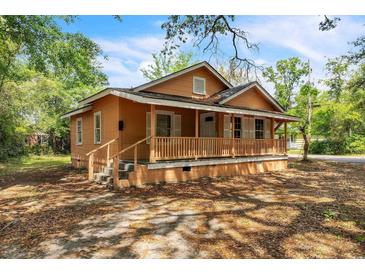 Charming single-story home featuring a welcoming front porch with wood railings and shuttered windows at 1800 9Th Ave., Conway, SC 29527